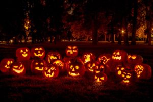 a group of bright carved pumpkins at night